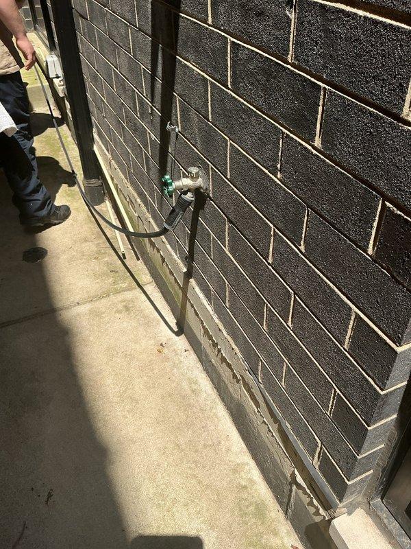 Performed site assessment for main exterior drain cleanout located outside basement door. Inspected exterior cleanout access point mounted on brick wall foundation and evaluated interior plumbing system connections including main drain stack, water heater installation, and associated relief valve components. Documented existing conditions of drainage system and plumbing infrastructure to prepare comprehensive estimate for main drain cleaning services.