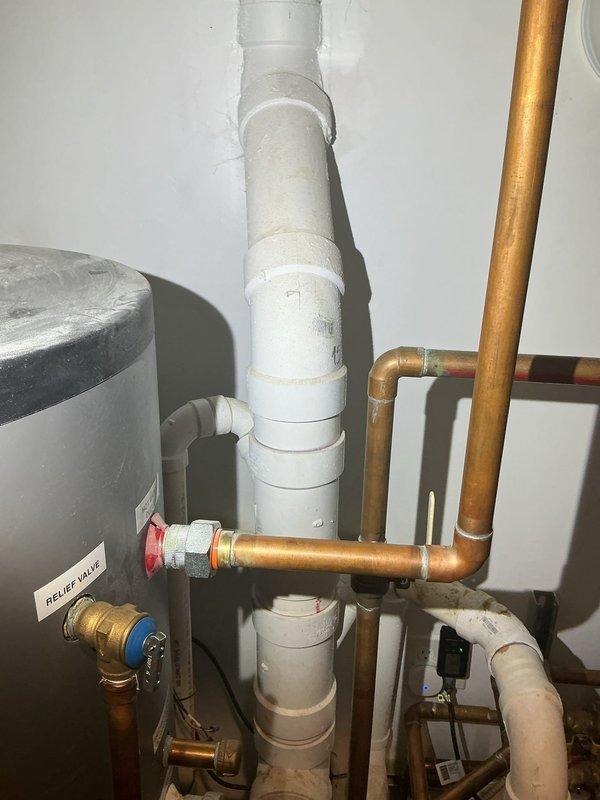 Performed site assessment for main exterior drain cleanout located outside basement door. Inspected exterior cleanout access point mounted on brick wall foundation and evaluated interior plumbing system connections including main drain stack, water heater installation, and associated relief valve components. Documented existing conditions of drainage system and plumbing infrastructure to prepare comprehensive estimate for main drain cleaning services.