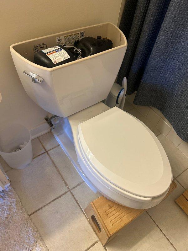 Completed toilet installation in residential bathroom. Installed new two-piece white porcelain toilet with standard flush mechanism and chrome handle. Connected water supply line to tank and verified proper fill valve and flapper operation. Tested flush performance and checked for leaks at all connection points. Ensured proper seating of toilet bowl to floor flange with secure mounting. All components functioning correctly upon completion.