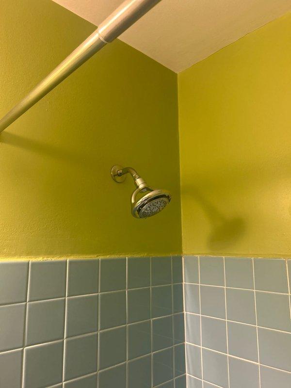 Responded to a shower hot water issue in a 40-year-old residence where the cartridge was suspected to be clogged due to extended non-use. Upon arrival, coordinated with the property association to shut off the water supply to the unit. Accessed the shower valve assembly behind the teal-tiled tub surround, which featured older-style chrome cross-handle faucet controls. Removed and inspected the hot water cartridge, confirming sediment buildup and debris accumulation from the prolonged period of inactivity. Cleaned the cartridge thoroughly, flushed the valve body to remove any remaining debris, and reinstalled the component. Restored water supply and tested both hot and cold water flow through the tub spout and shower head to verify proper operation and temperature control. System returned to normal functioning with adequate hot water delivery.
