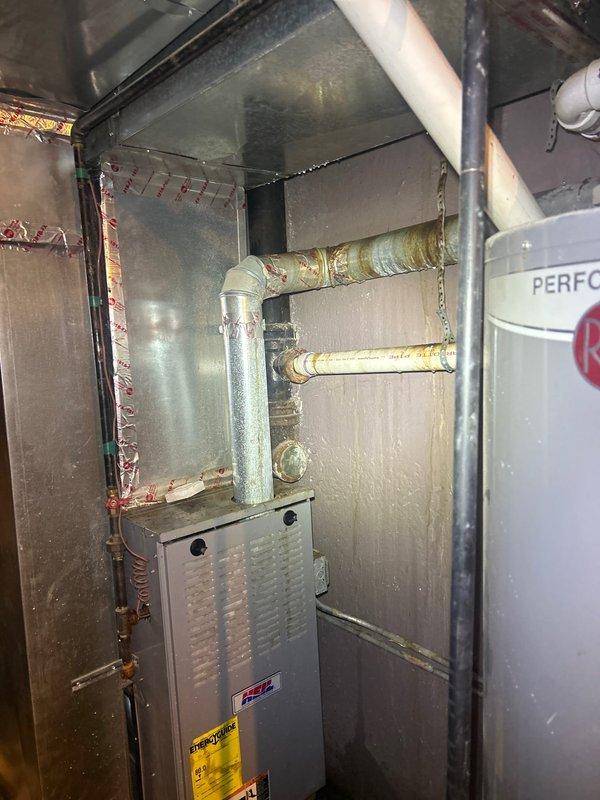 Responded to water leak investigation at residential property where water from upstairs bathroom was penetrating into main level bathroom ceiling. Upon arrival, access opening had already been created in ceiling to expose affected area. Conducted thorough inspection of upstairs bathroom plumbing fixtures, including bathtub drain assembly and surrounding connections visible in corner junction between tub and vanity cabinet. Examined basement mechanical room to assess water supply lines, insulated piping, and potential leak sources in plumbing infrastructure above main level bathroom. Documented conditions with photographs showing upstairs bathroom fixture connections and basement plumbing configuration to identify leak origin and provide repair recommendations.