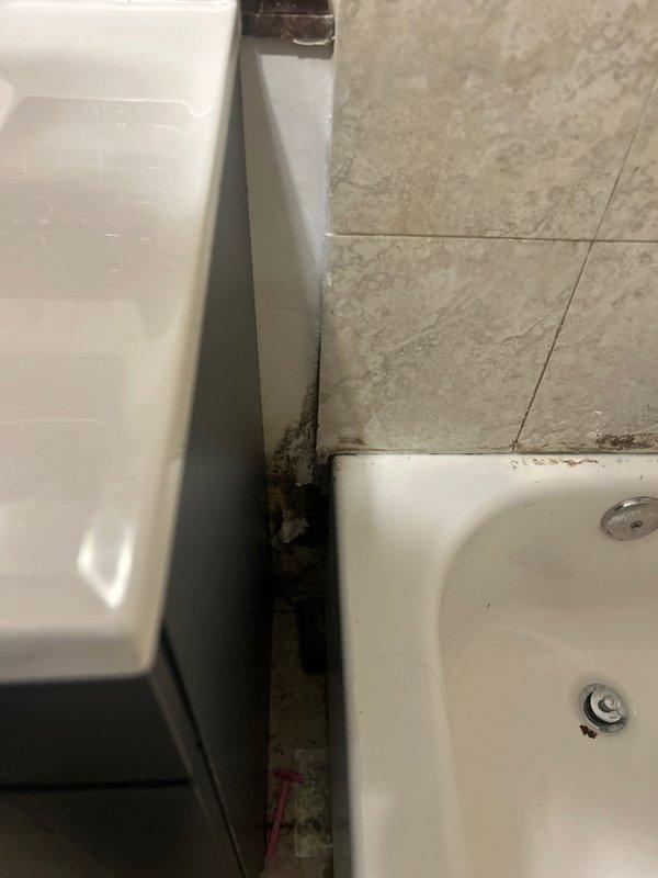 Responded to water leak investigation at residential property where water from upstairs bathroom was penetrating into main level bathroom ceiling. Upon arrival, access opening had already been created in ceiling to expose affected area. Conducted thorough inspection of upstairs bathroom plumbing fixtures, including bathtub drain assembly and surrounding connections visible in corner junction between tub and vanity cabinet. Examined basement mechanical room to assess water supply lines, insulated piping, and potential leak sources in plumbing infrastructure above main level bathroom. Documented conditions with photographs showing upstairs bathroom fixture connections and basement plumbing configuration to identify leak origin and provide repair recommendations.