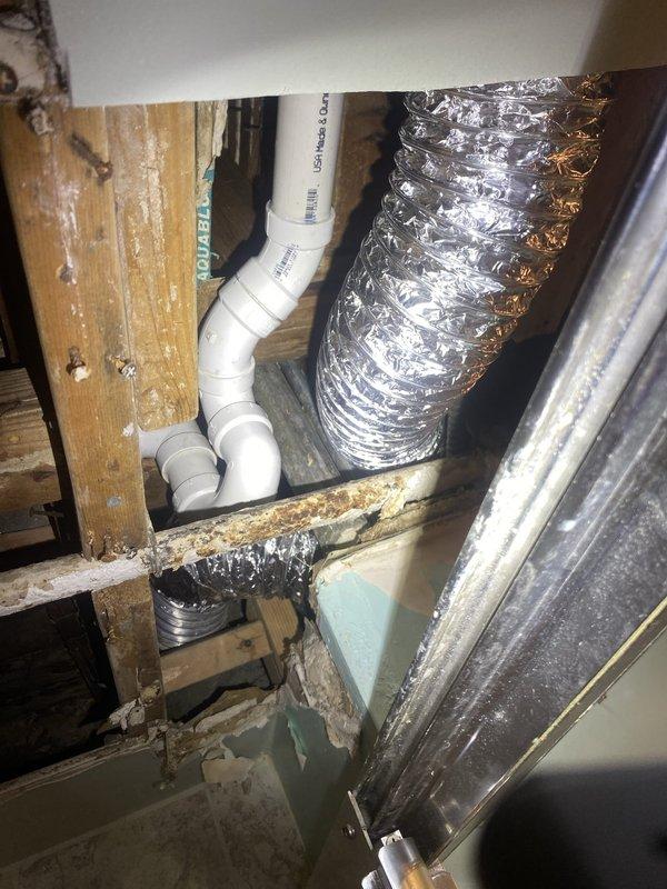 Completed installation of brass bathtub waste and overflow assembly, including chrome-plated overflow plate with lever-style drain control, brass drain piping with 90-degree elbow configuration, and decorative drain strainer. Accessed confined crawl space to connect drain assembly to existing PVC waste line, routing new plumbing through floor joists while maintaining proper drainage slope and ensuring secure connections throughout the installation.