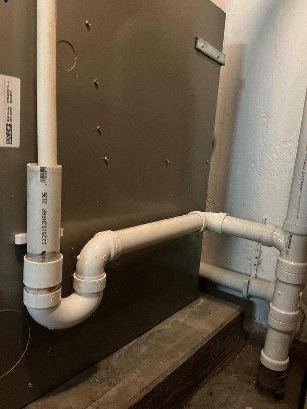 Completed installation of new PVC drainage piping system in utility space, including P-trap assembly and proper venting configuration. Replaced deteriorated plumbing infrastructure with code-compliant white PVC pipe connections, utilizing proper primer and solvent welding techniques to ensure leak-free joints at all T-junctions and elbow fittings.