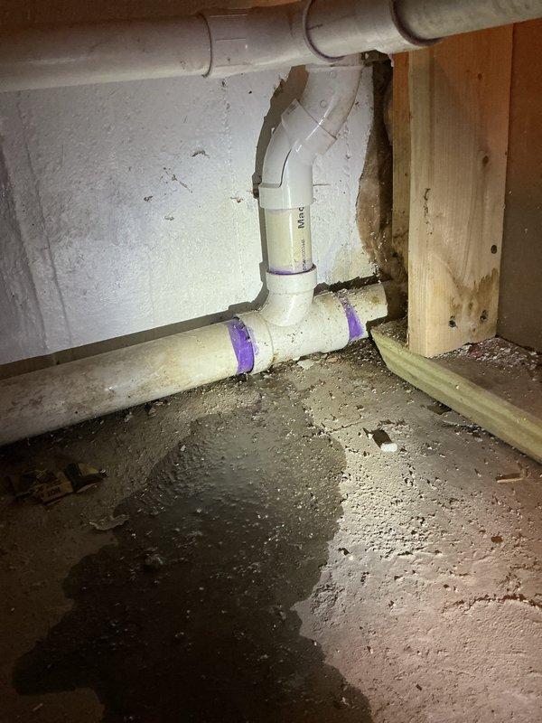 Completed installation of new PVC drainage piping system in utility space, including P-trap assembly and proper venting configuration. Replaced deteriorated plumbing infrastructure with code-compliant white PVC pipe connections, utilizing proper primer and solvent welding techniques to ensure leak-free joints at all T-junctions and elbow fittings.