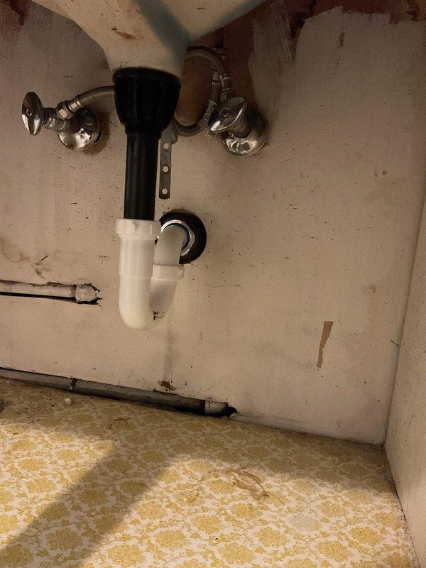 Responded to a blocked drain on the second floor of a 62-year-old residence. Upon investigation, accessed the drain system through the wall cavity, revealing the vertical plumbing stack and P-trap assembly. Removed blockage from the drain line, inspected all visible plumbing connections including PVC piping, elbow joints, and trap configuration under the sink for proper function and potential deterioration. All fixtures restored to proper drainage operation.