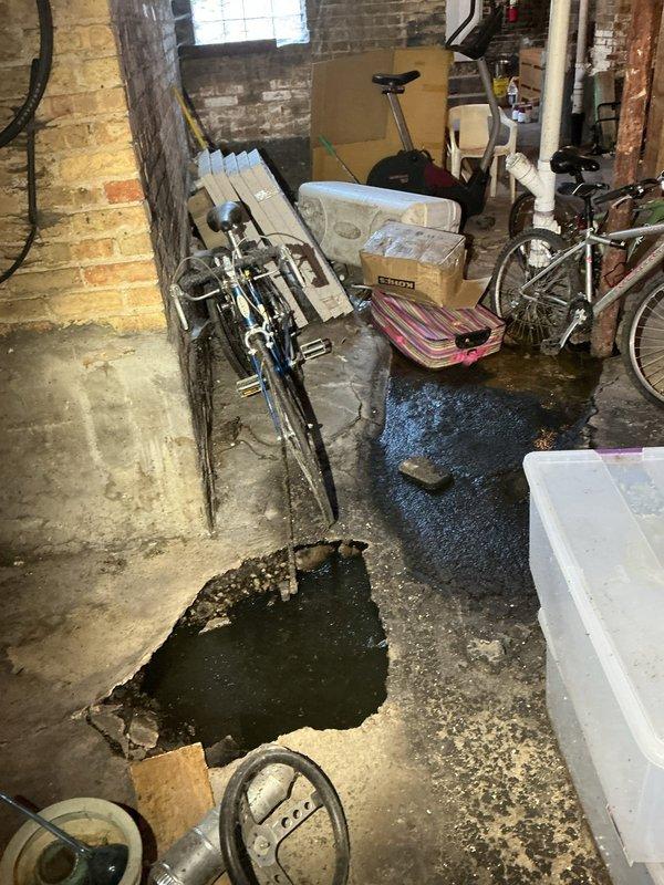 Responded to basement flooding issue caused by compromised sewer line drainage system. Upon arrival, documented extensive standing water accumulation on concrete floor with visible surface deterioration and staining throughout the storage area. Assessed existing floor drain functionality and identified cracking in concrete surface contributing to water infiltration, then coordinated scheduling for complete sewer line installation to resolve chronic drainage problems and prevent future water damage to the foundation and stored property.