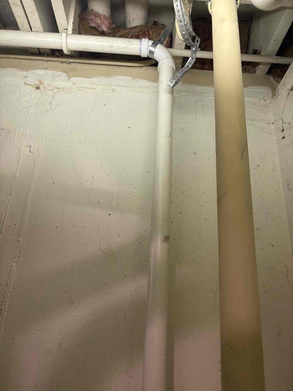 Responded to service call for leaking cast iron sewer pipe in basement of 50-year-old residential property. Upon arrival, conducted thorough inspection of existing plumbing system and identified minor leak in aging cast iron waste line. Assessed overall condition of basement plumbing infrastructure, including vertical PVC drain lines and waste pipe connections visible along foundation walls. Documented existing pipe configuration with multiple vertical runs, rubber coupling connections, and various junction points. Evaluated floor conditions around plumbing area, noting deteriorated surface coating and potential moisture concerns related to leak. Inspected sump pump system as requested, including examination of pump basin cover and surrounding drainage components. Provided consultation regarding sump pump operation, maintenance requirements, and recommendations for basement moisture management. Photographed existing plumbing conditions for reference, showing current PVC installation, p
