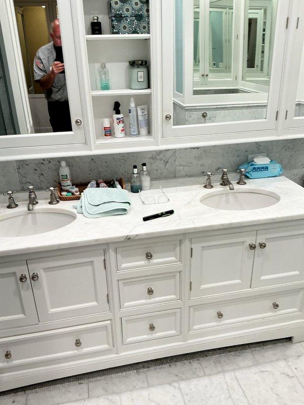 Responded to service call for leaking faucet handles in residential bathroom. Upon arrival, inspected double sink vanity configuration with traditional chrome faucets and separately examined vintage Chicago Faucet Co. fixtures showing significant age-related deterioration. Primary issue identified as leaking handles caused by worn internal components and deteriorated seals. Both affected faucet handles exhibited mineral buildup and corrosion consistent with extended service life. Assessed condition of fixtures, documented existing water damage and staining on surrounding porcelain surfaces, and provided recommendations for repair or replacement options to resolve the active leaks.