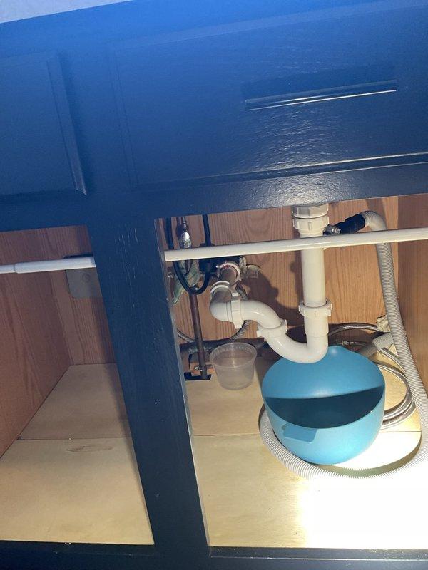 Responded to service call for slow draining kitchen sink and leak under sink. Upon inspection, identified drainage issue in kitchen sink P-trap assembly and confirmed active leak at pipe connections beneath sink cabinet. Inspected under-sink plumbing system including white PVC P-trap, supply lines, and shut-off valves. Examined basement/crawl space plumbing infrastructure including copper drain lines, PVC drainage piping, and associated fittings to assess overall drain line condition and identify potential blockage points. Documented existing plumbing configuration with photographs showing pipe routing, connections, and areas of concern for estimate preparation.