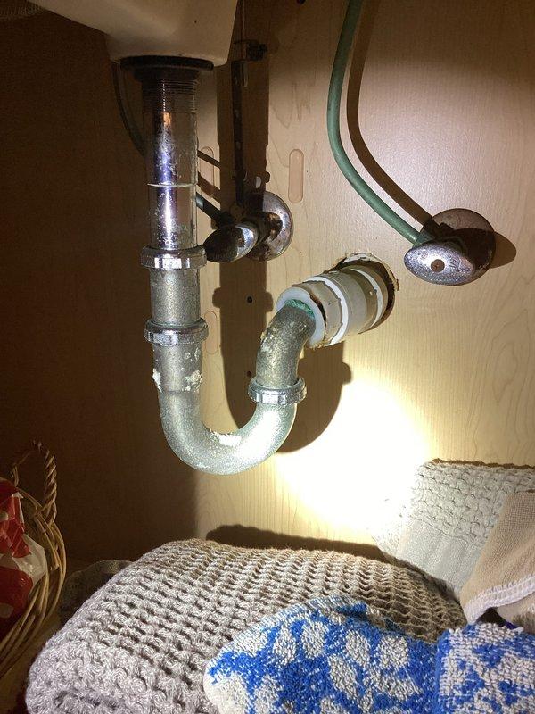 Completed replacement of corroded shut-off valve under kitchen sink due to deteriorated condition and potential leak risk. Addressed secondary plumbing concerns including heavily oxidized copper supply lines showing significant green patina buildup. Inspected P-trap assembly and drain connections, which displayed water staining and mineral deposits but remained structurally sound. Verified proper operation of new shut-off valve and tested all connections for leaks. All plumbing fixtures are now functioning correctly with improved water control capability.