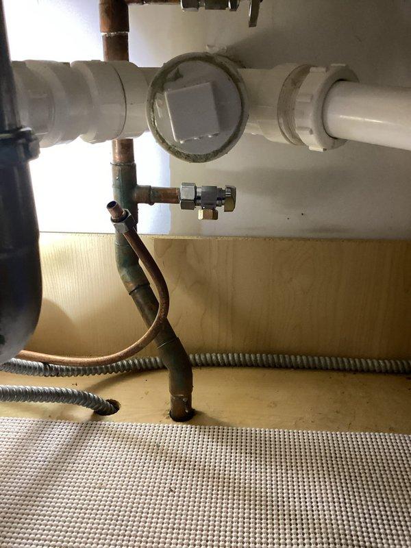 Completed replacement of corroded shut-off valve under kitchen sink due to deteriorated condition and potential leak risk. Addressed secondary plumbing concerns including heavily oxidized copper supply lines showing significant green patina buildup. Inspected P-trap assembly and drain connections, which displayed water staining and mineral deposits but remained structurally sound. Verified proper operation of new shut-off valve and tested all connections for leaks. All plumbing fixtures are now functioning correctly with improved water control capability.