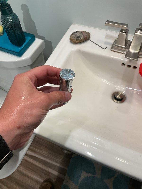 Responded to service call for Hansgrohe rain shower head with no water flow while handheld shower functioned properly. Diagnosed faulty diverter valve preventing water from reaching overhead rain head fixture. Removed and inspected chrome diverter component, confirmed internal mechanism failure causing complete flow blockage to rain head position. Replaced defective diverter valve with new unit, restored full water flow to rain shower head, and verified proper operation of both shower functions.
