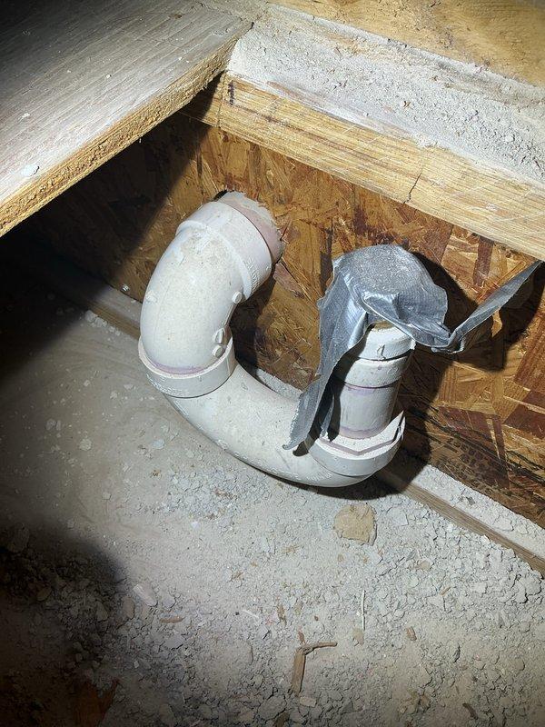 Completed rough plumbing installation in new construction bathroom, including installation of PVC drain trap assembly with proper venting configuration and copper water supply lines with brass fittings. Secured all plumbing connections, installed floor drain flange, and verified proper drainage flow through the waste system before proceeding to next phase of construction.