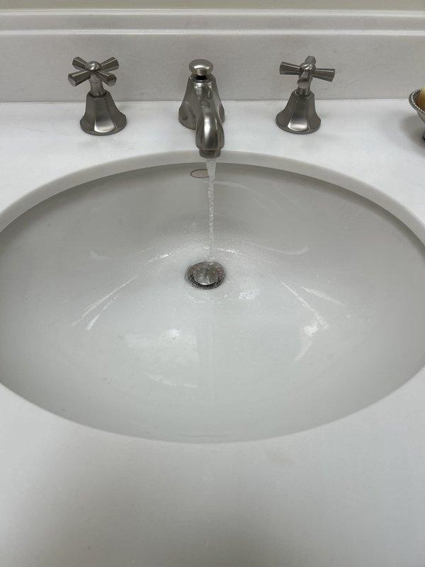 Completed installation of three-piece widespread lavatory faucet with cross handles and brushed nickel finish on bathroom vanity with undermount sink. Verified proper water flow, tested both hot and cold supply lines, and confirmed drain assembly operation with no leaks detected.