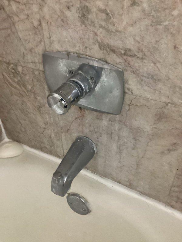 Completed plumbing estimate for shower diverter replacement in high-rise residential bathroom. Inspected chrome tub spout with faulty diverter mechanism and shower valve assembly mounted on marble-patterned tile wall. Customer informed of high-rise service fee waiver if proceeding with recommended repair work.