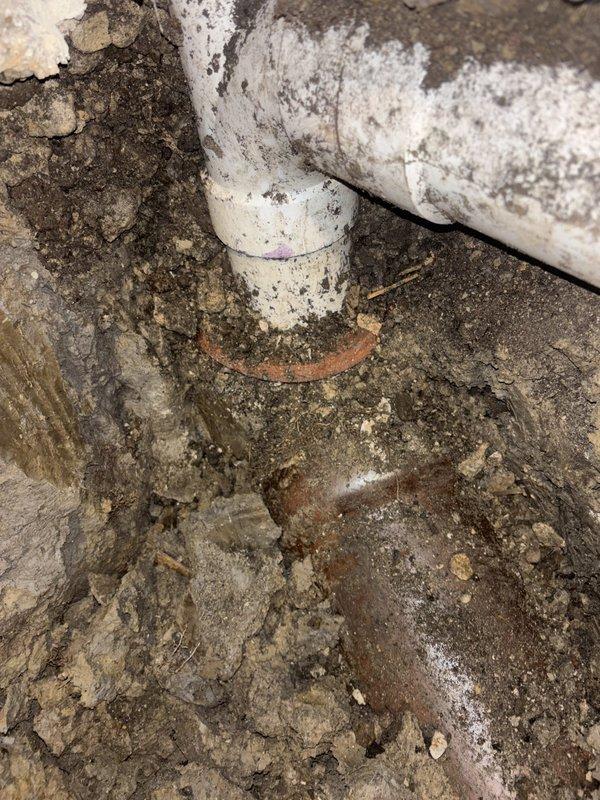 Completed sewer line installation in crawl space area with exposed soil and structural elements. Installed new PVC piping system with proper fittings and connections, addressing moisture concerns and deteriorated conditions in the workspace. Work included proper pipe routing, secure mounting to structural beams, and ensuring all connections meet code requirements for long-term drainage functionality.