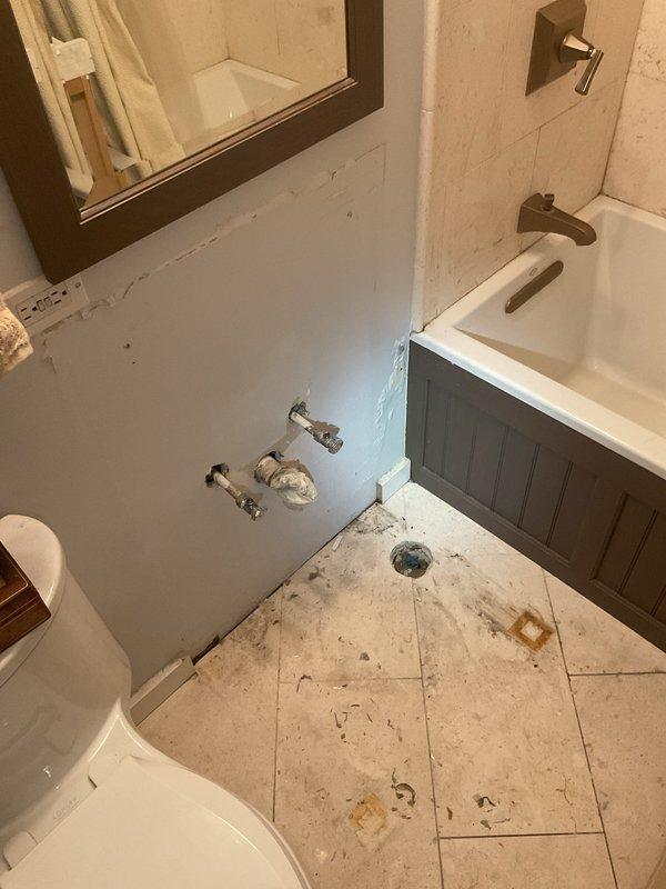 Responded to a clogged sink that had persisted for two weeks in a residential bathroom. Upon arrival, inspected the under-sink plumbing assembly, which consisted of white PVC P-trap configuration with chrome tailpiece extension and flexible supply lines. Assessed the drain system for blockages and proper venting. Cleared the obstruction using appropriate drain cleaning techniques, restoring full drainage capacity to the fixture. Tested water flow through the system to confirm proper operation and verified the P-trap seal was intact with no leaks present. All plumbing connections remained secure throughout the service, and the drain now operates at normal flow rate with no backup or slow drainage issues.