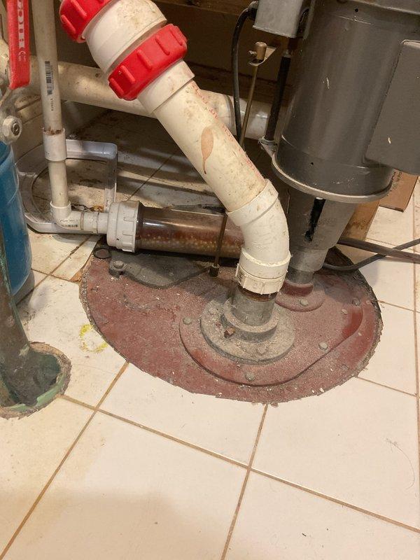 Responded to service call for low water pressure throughout the home following recent water heater installation. Conducted comprehensive inspection of plumbing system to identify cause of reduced flow. Examined freestanding bathtub fixture assembly with polished chrome and ceramic finishes, verifying proper operation of dual cross-handle controls and handheld shower component. Assessed water pressure at multiple fixtures to establish baseline measurements.

Inspected mechanical room installation including water heater connections and associated piping. Identified corroded horizontal pipe shaft and deteriorated components within floor-mounted circular access plate assembly. Evaluated white PVC discharge piping with visible wear and discoloration, along with adjacent pump or motor assembly showing signs of age. Checked all connection points for potential restrictions or blockages affecting system pressure.

Performed system diagnostics to determine if pressure issues stemmed from new wat