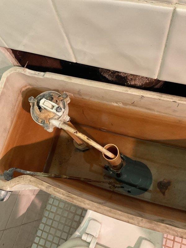 Responded to service call for multiple toilet issues at residential property. Upon arrival, addressed clogged toilet using standard drain clearing techniques to restore proper flushing function. Inspected second toilet with reported internal component failure and documented deteriorated tank components, including corroded flush valve assembly with broken parts, aging fill valve mechanism, and extensive rust staining throughout tank interior indicating long-term mineral deposit buildup and component degradation. Photographed tank conditions showing compromised internal hardware requiring replacement to restore reliable operation.