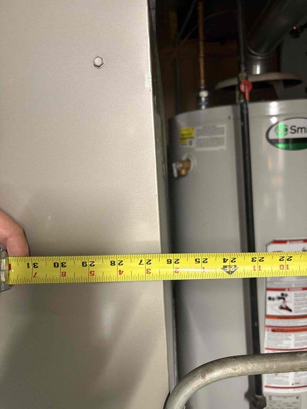 Conducted comprehensive assessment of existing water heater installation in basement of 1961-built home to provide replacement options. Evaluated current A.O. Smith unit with chimney venting configuration, documented clearances and spatial dimensions between equipment and adjacent walls, and photographed existing plumbing connections including copper supply lines and venting arrangement. Provided homeowner with replacement recommendations suitable for existing chimney vent infrastructure and basement installation requirements.