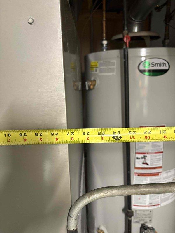 Conducted comprehensive assessment of existing water heater installation in basement of 1961-built home to provide replacement options. Evaluated current A.O. Smith unit with chimney venting configuration, documented clearances and spatial dimensions between equipment and adjacent walls, and photographed existing plumbing connections including copper supply lines and venting arrangement. Provided homeowner with replacement recommendations suitable for existing chimney vent infrastructure and basement installation requirements.