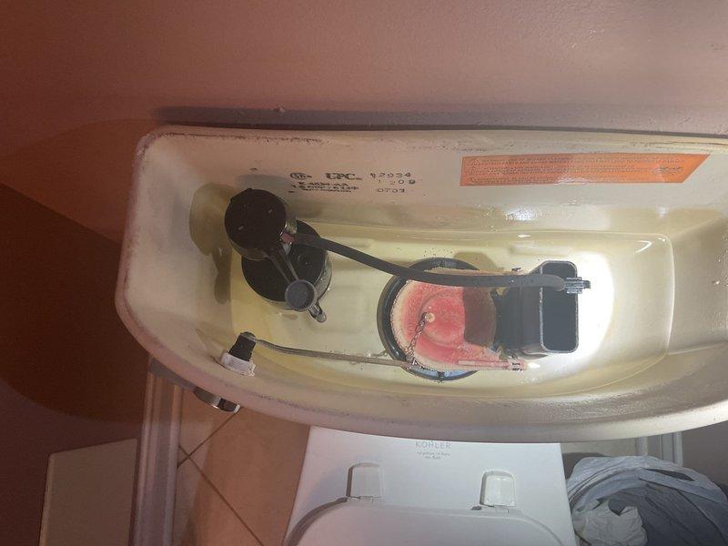 Responded to service call for leaking toilet. Upon inspection, identified issue with flush valve assembly and flapper mechanism in Kohler toilet tank. Tank interior showed significant mineral buildup and discoloration indicating age-related wear. Inspected fill valve, float assembly, and flush chain connections for proper operation. Documented existing condition of tank components including CSA and UPC certified flush valve system. Assessed tank integrity and identified source of water leak from compromised flapper seal, allowing water to continuously seep into bowl. Photographed internal tank components and manufacturer specifications for service records.