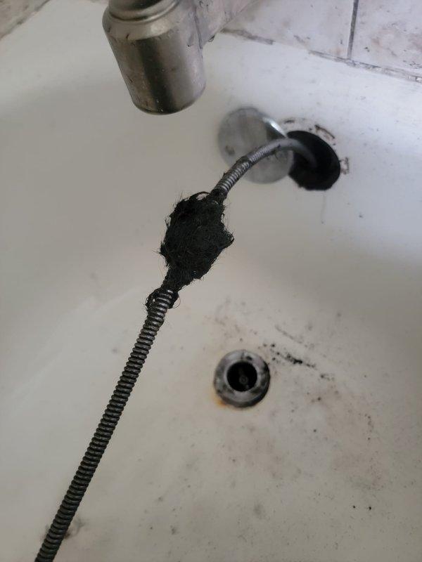 Responded to a clogged drain service call and successfully cleared a bathtub drain obstruction using a flexible drain auger. Extracted a significant accumulation of hair and organic debris that was blocking the drain line, restoring proper drainage function to the fixture.
