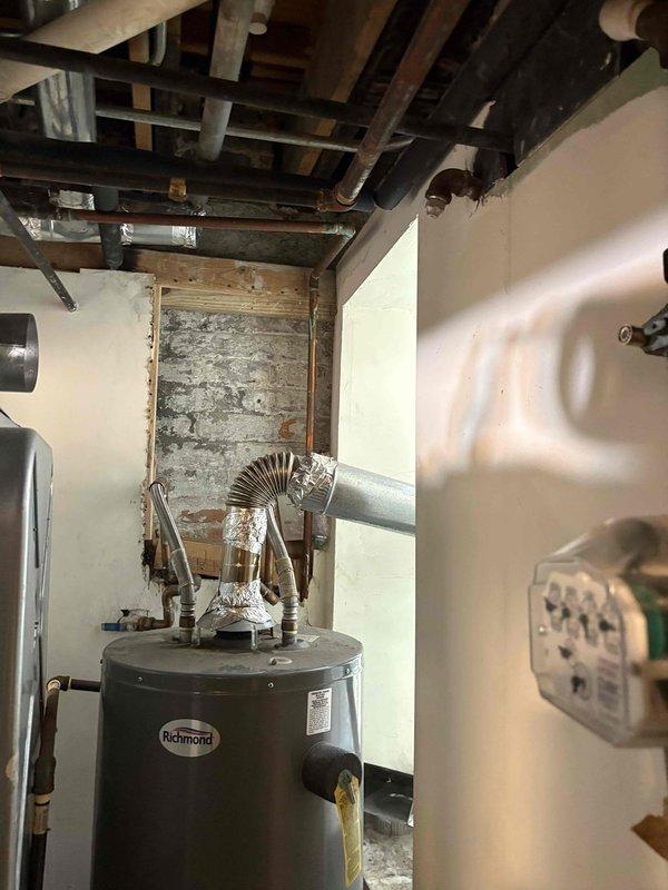 Performed comprehensive pressure testing on residential plumbing system including complex manifold assembly with multiple copper and brass pipe connections. System tested successfully with all connections, fittings, and aged piping holding proper pressure without leaks detected.