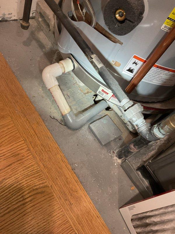 Responded to a clogged floor drain concern in the HVAC utility room. Upon inspection, identified active water damage to ceiling materials with visible staining and deterioration, indicating a leak from the floor above was potentially contributing to drainage issues in the lower level. Documented existing plumbing configuration including water heater connections, copper supply lines, and PVC drainage system for further evaluation and estimate preparation.