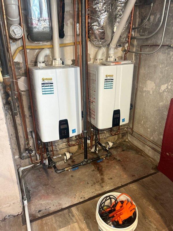 Performed comprehensive VIP maintenance service on dual Coorie tankless water heater system. Conducted complete descaling and flushing procedure using circulation pump and cleaning solution to remove mineral buildup and maintain optimal heat exchanger efficiency. Inspected all plumbing connections, shut-off valves with red handles, brass fittings, and multi-colored supply lines for proper operation and potential leaks. Verified digital control panel functionality on both units and confirmed Energy Star rated performance standards were maintained. Examined venting system including white PVC exhaust pipes and metallic flexible ductwork for proper installation and clearances. Assessed overall system performance and confirmed both tankless units operating within manufacturer specifications.