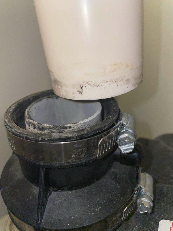 Responded to emergency service call for disconnected exhaust vent pipe on tanked water heater in utility closet. Upon arrival, confirmed that the white PVC exhaust vent pipe had separated from the rubber coupling connection at the ceiling overnight, causing a loud noise that prompted the occupant to shut off the electrical breaker and gas supply as a safety precaution. 

Inspected the exhaust vent assembly and identified that the rubber coupling with metal hose clamps had failed, allowing the vertical PVC pipe to disconnect from the water heater's exhaust system. Verified no water leaks or damage to surrounding areas. Cleaned accumulated dirt and debris from the pipe connection points and coupling surfaces to ensure proper seal. Reinstalled the exhaust vent pipe into the rubber coupling adapter, ensuring proper alignment and secure fit. Tightened metal hose clamps on both sections of the coupling to manufacturer specifications to prevent future disconnection.

Restored gas supply and e