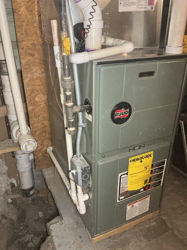 Responded to callback for toilet and sink reinstallation and discovered the root cause of recurring sewer backup issues. Upon investigation, identified that the existing 4" tee configuration had drain branches from the basement bathroom, laundry room, and toilet stack positioned lower than the main sewer line, creating an uphill flow condition that prevented proper drainage.

Broke up concrete flooring and excavated in storage room to expose the existing main sewer line. Removed the toilet stack from the no-hub coupling down to the horizontal connection point. Installed new toilet stack section using 4" PVC pipe and fittings, incorporating a new connection for ejector pump discharge, sump pump discharge tie-in, and cleanout access for future maintenance requirements. Connected the toilet stack to the main sewer using appropriate transition fittings to ensure code-compliant installation.

Installed new polyethylene ejector pit and ejector pump adjacent to the furnace location. Piped the