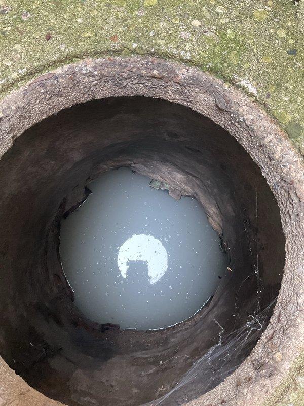 Responded to service call for catch basin rodding. Upon arrival, inspected the drainage structure and found standing water at the bottom with visible corrosion and deterioration along the interior walls. Performed rodding service from the catch basin to clear the blockage and restore proper drainage flow. The structure showed signs of age with mineral deposits and algae growth, but rodding operation was completed successfully to address the clog.