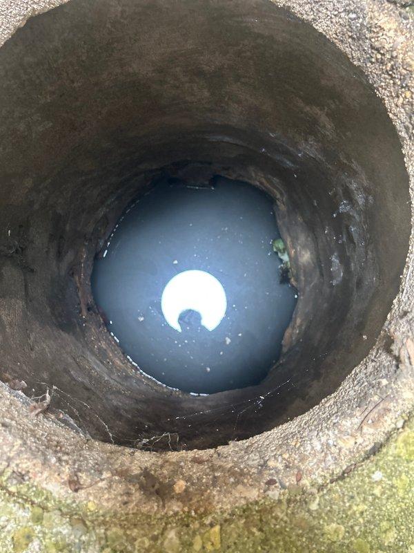 Responded to service call for catch basin rodding. Upon arrival, inspected the drainage structure and found standing water at the bottom with visible corrosion and deterioration along the interior walls. Performed rodding service from the catch basin to clear the blockage and restore proper drainage flow. The structure showed signs of age with mineral deposits and algae growth, but rodding operation was completed successfully to address the clog.