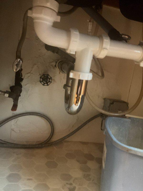 Responded to kitchen sink backup and clog. Upon arrival, inspected the drain assembly beneath the sink and identified blockage in the P-trap. Disassembled the PVC trap configuration, cleared accumulated debris causing the obstruction, and reassembled all connections. Tested drainage flow to confirm proper operation and verified no leaks at trap connections or supply line fittings.