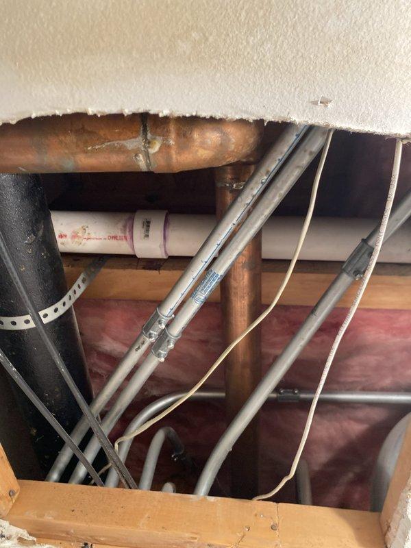 Conducted comprehensive drain and sewer system assessment for commercial property through ceiling and wall access points. Inspection revealed corroded copper piping with significant patina buildup, multiple PVC drain lines, and compromised structural access areas requiring attention. Documented existing plumbing infrastructure conditions, including various diameter pipes, conduits, and utility lines for estimate preparation and recommended repairs to address corrosion issues and restore proper access point integrity.