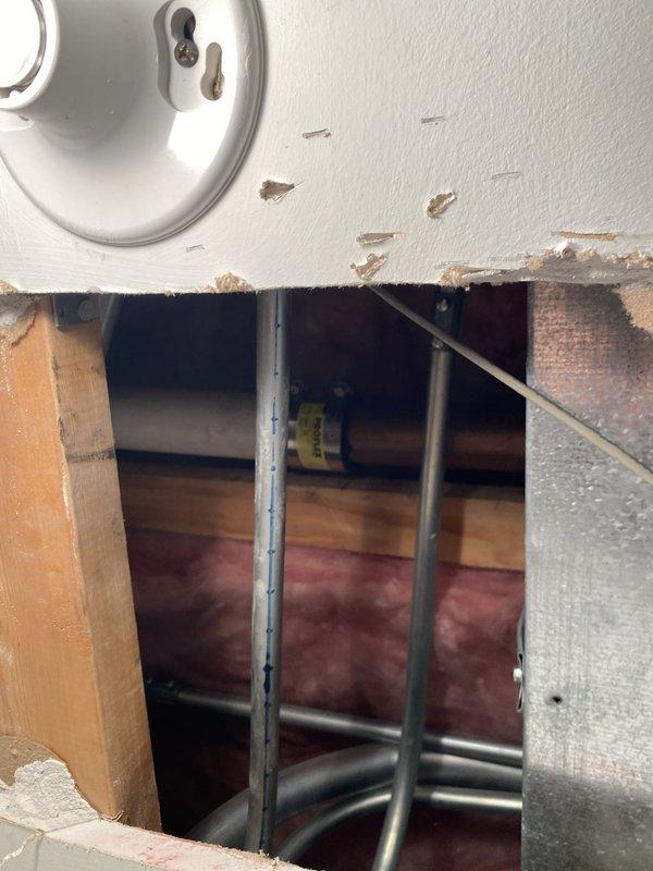 Conducted comprehensive drain and sewer system assessment for commercial property through ceiling and wall access points. Inspection revealed corroded copper piping with significant patina buildup, multiple PVC drain lines, and compromised structural access areas requiring attention. Documented existing plumbing infrastructure conditions, including various diameter pipes, conduits, and utility lines for estimate preparation and recommended repairs to address corrosion issues and restore proper access point integrity.