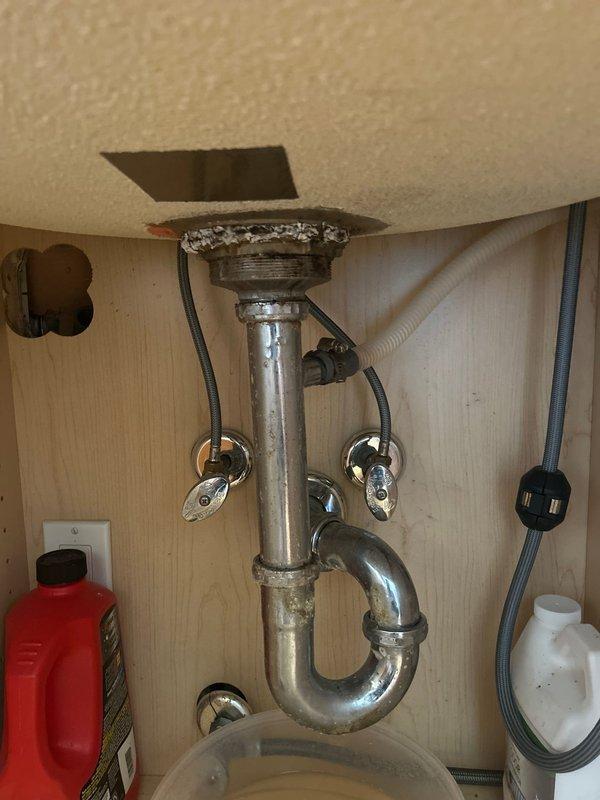 Responded to kitchen sink leak complaint. Inspected under-sink plumbing assembly including P-trap, tailpiece, and water supply connections. Examined chrome-plated drain assembly, shut-off valves with flexible supply lines, and all connection points for signs of moisture or active leaking. Documented existing plumbing configuration and condition of fixtures. All components photographed for assessment and estimate preparation.