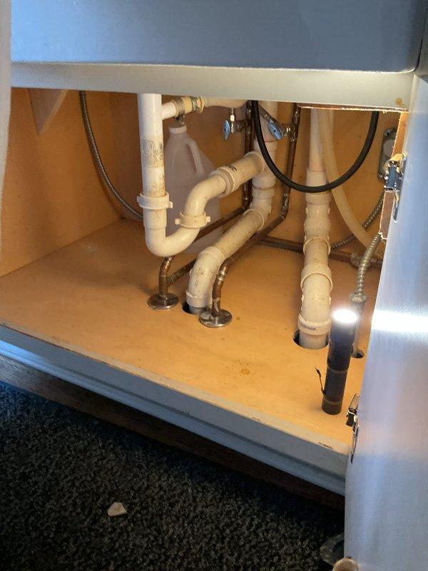 Responded to kitchen sink clog with suspected main line blockage in 18-year-old residence. Upon arrival, accessed sink drain assembly and inspected P-trap and drain connections beneath cabinet to verify blockage location. Routed main drain line through cleanout access point to clear obstruction and restore proper drainage flow. Given history of similar issue two months prior, advised customer of potential recurring drainage concerns that may require further evaluation of main sewer line condition.