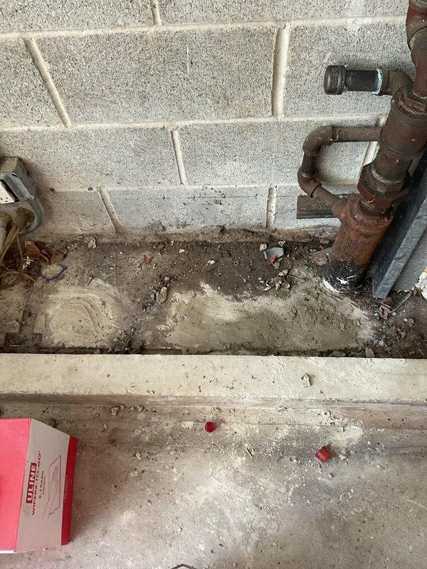 Inspected and assessed deteriorated plumbing infrastructure in basement utility area, including heavily corroded vertical pipe with significant rust oxidation and failing fittings requiring replacement. Documented existing conditions of aging plumbing system with pressure gauge assembly and PVC piping network to provide customer with visual evidence supporting recommended repair work sold during morning consultation.