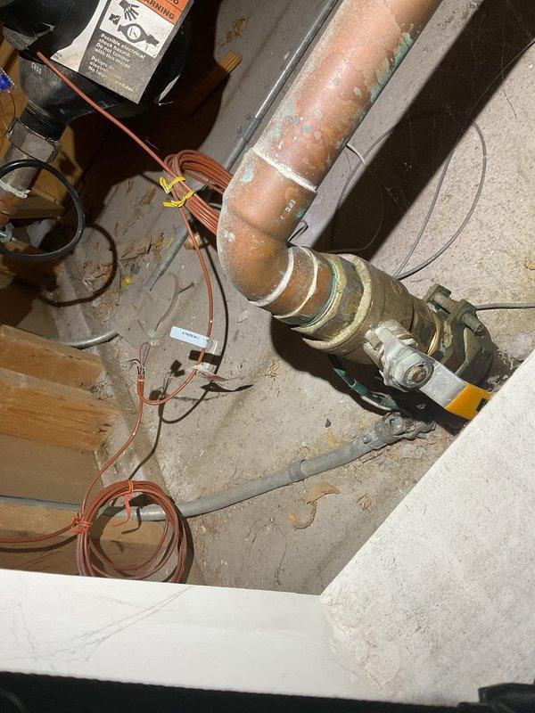 Responded to water leak investigation between third floor master bathroom and second floor bathroom ceiling. Conducted visual inspection of affected areas, documenting visible water staining on second floor ceiling directly below master bathroom. Inspected plumbing fixtures, supply lines, and drainage systems in master bathroom to identify source of moisture intrusion. Photographed mechanical equipment and plumbing connections in utility area, including aged copper piping with visible corrosion and patina buildup on pump assembly. Documented kitchen plumbing fixtures and connections as part of comprehensive leak source investigation. Captured photographic evidence of all inspected areas for diagnostic assessment and recommended repairs.