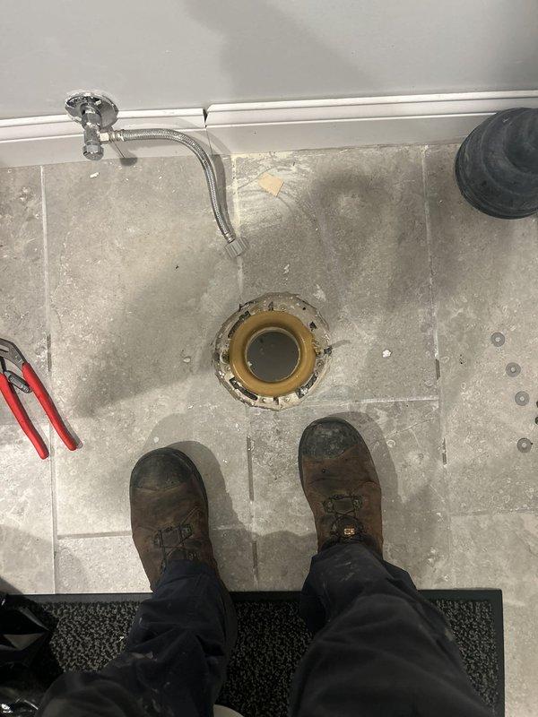 Responded to complaint of foul odor emanating from basement drain. Upon inspection, removed toilet flange assembly to access drain line. Discovered accumulated debris and buildup within the drain system causing the malodorous condition. Extracted foreign material and organic matter from the line. Cleaned flange assembly and surrounding components, removing sediment and grime. Cleared obstruction to restore proper drainage flow and eliminate odor source. Reassembled components and verified system function upon completion.