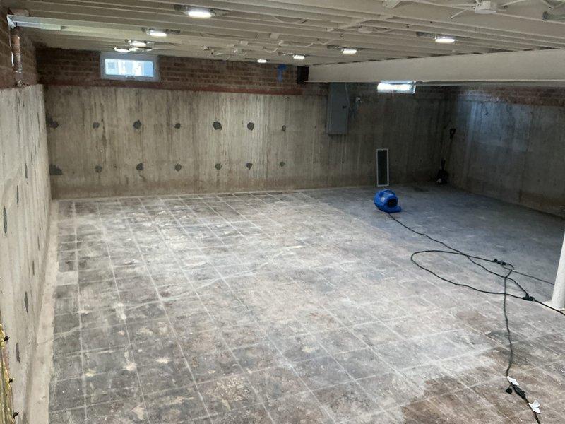 Completed plumbing assessment and repair consultation for basement renovation project. The unfinished basement space showed evidence of moisture intrusion with visible water staining and discoloration on concrete walls and floor surfaces. Deployed air moving equipment and dehumidification unit to address moisture concerns and facilitate proper drying of the affected areas. Inspected existing plumbing infrastructure in mechanical room, including water heater connections, drainage systems, and exposed piping. Documented current conditions of concrete surfaces, which displayed typical poured concrete construction patterns with moisture penetration indicators. Evaluated HVAC and plumbing system integration in utility area to ensure proper function and identify any potential issues related to water damage or seepage. Recommended continued use of drying equipment until moisture levels return to acceptable standards before proceeding with renovation work.