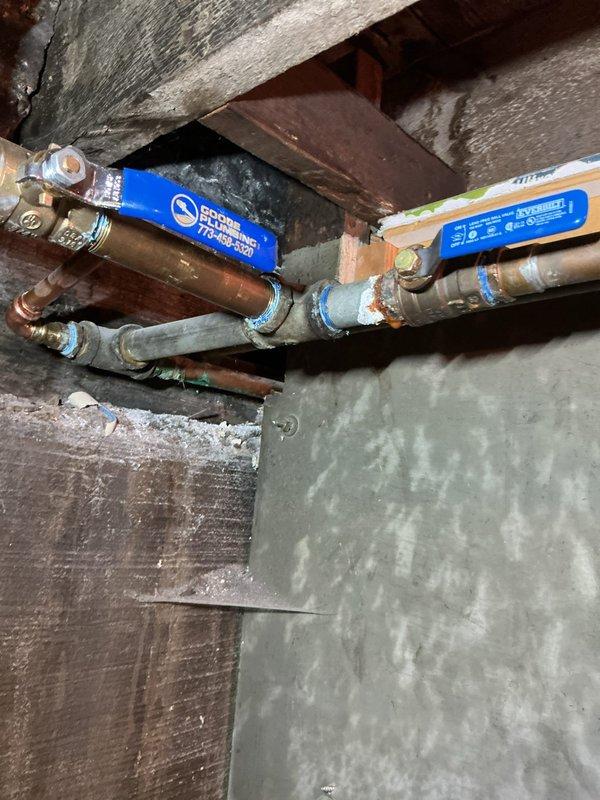 Installed two blue ball valves with copper and flexible piping connections in basement crawl space area. Standard stock plumbing components were secured to existing wooden structural supports, with all fittings and connectors properly assembled to ensure reliable water flow control and system integrity.