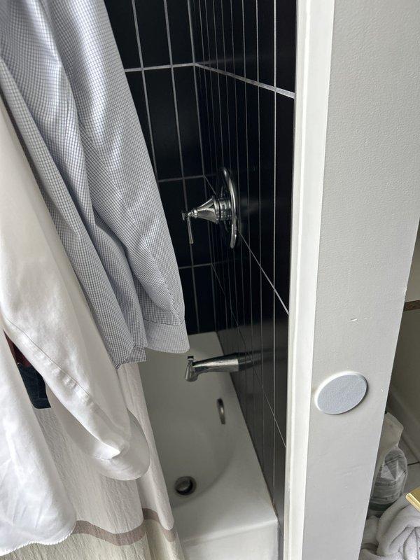 Completed plumbing inspection and repair consultation for bathroom shower system. Assessed chrome tub spout and handheld showerhead assembly mounted on tiled shower enclosure with navy subway tile finish. Documented existing fixtures and provided recommendations for necessary repairs to ensure proper water flow and prevent potential leaks.