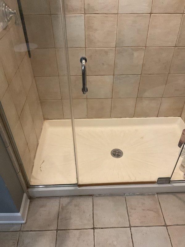 Responded to water leak investigation with wall already opened and exposed for access. Inspected walk-in shower stall showing visible streaking and discoloration on shower pan surface, examined exposed ceiling/floor joist cavity with HVAC ductwork to locate leak source. Documented conditions with photos of shower enclosure and opened wall cavity for further assessment and repair recommendations.