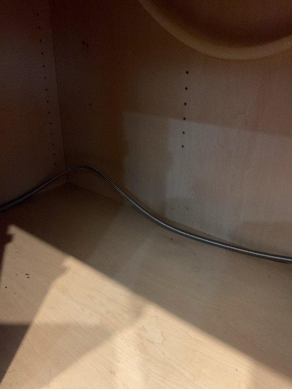 Responded to a low water pressure issue affecting dishwasher operation. Upon inspection of the under-sink plumbing, examined the water supply lines, shutoff valves, and connection points serving the dishwasher. Assessed the braided stainless steel supply lines and verified proper flow from the main supply valves. Checked for debris, sediment buildup, or partial valve closure that could restrict water flow to the dishwasher inlet. Documented existing plumbing configuration including P-trap assembly, garbage disposal unit, and supply line routing for reference.