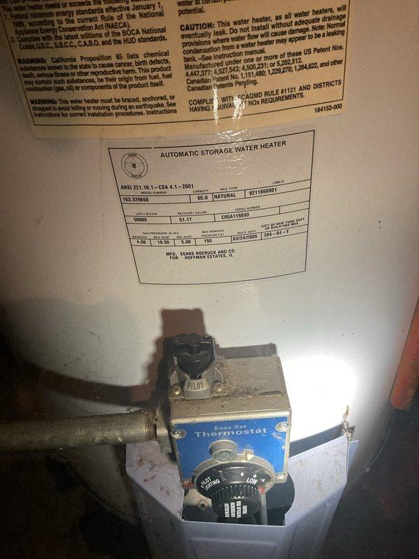 Conducted commercial drain and sewer estimate inspection of basement utility area housing multiple water heating systems. Documented existing plumbing infrastructure including extensive copper piping network, PVC ductwork, and water heater installations with thermostat controls and safety specifications. Assessment revealed aging mechanical components with visible dust accumulation on thermostat housing and connections, requiring evaluation for potential drain line servicing and preventative maintenance recommendations.
