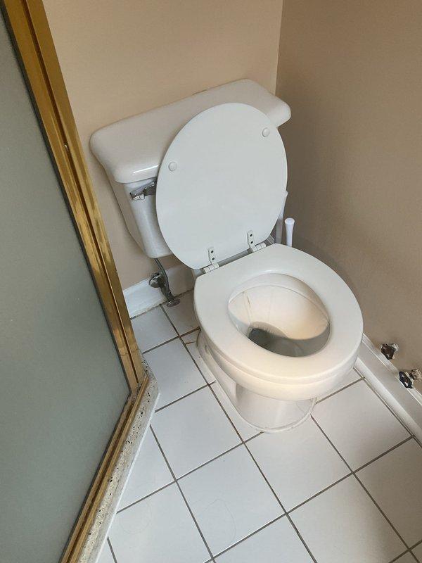Responded to service call for multiple bathroom plumbing issues. Inspected toilet with reported running condition and broken seat. Assessed toilet tank components including flapper valve, fill valve, and flush mechanism for continuous water flow issue. Documented existing two-piece toilet condition and accessibility of supply line connections. Inspected crawl space plumbing infrastructure beneath bathroom, including copper and PVC drain lines to evaluate replacement feasibility. Photographed toilet fixture and underlying plumbing system for customer review regarding potential full toilet replacement versus component repair options.